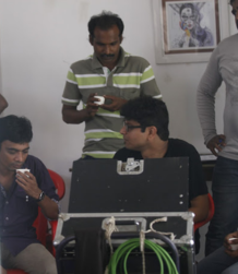 Three people are sipping tea in front of a monitor during an ad-filmmaking production service